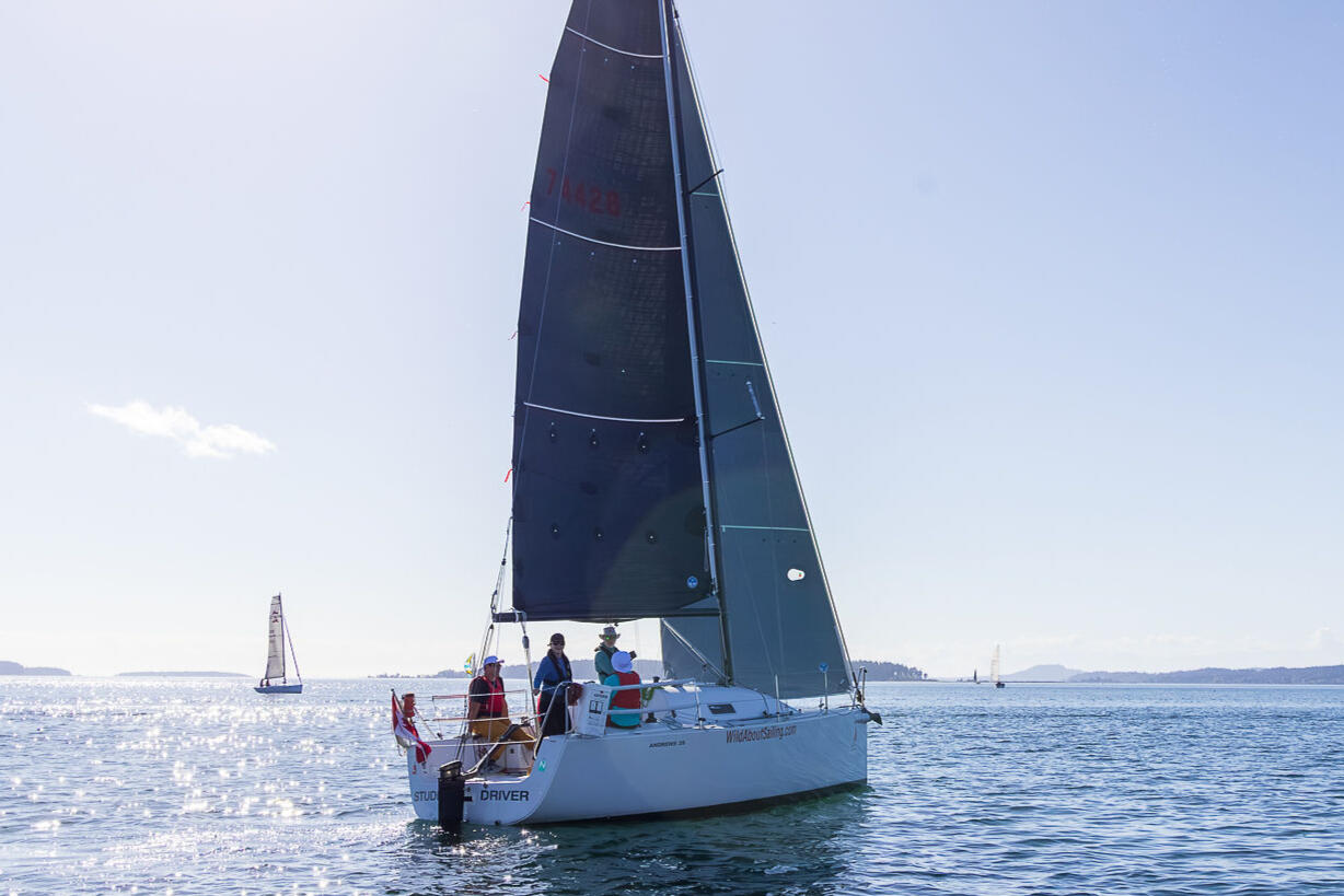 Student Driver A small group of sailors aboard a keelboat under sail in BC's Gulf Islands during a Sail Canada certified sailing course.
